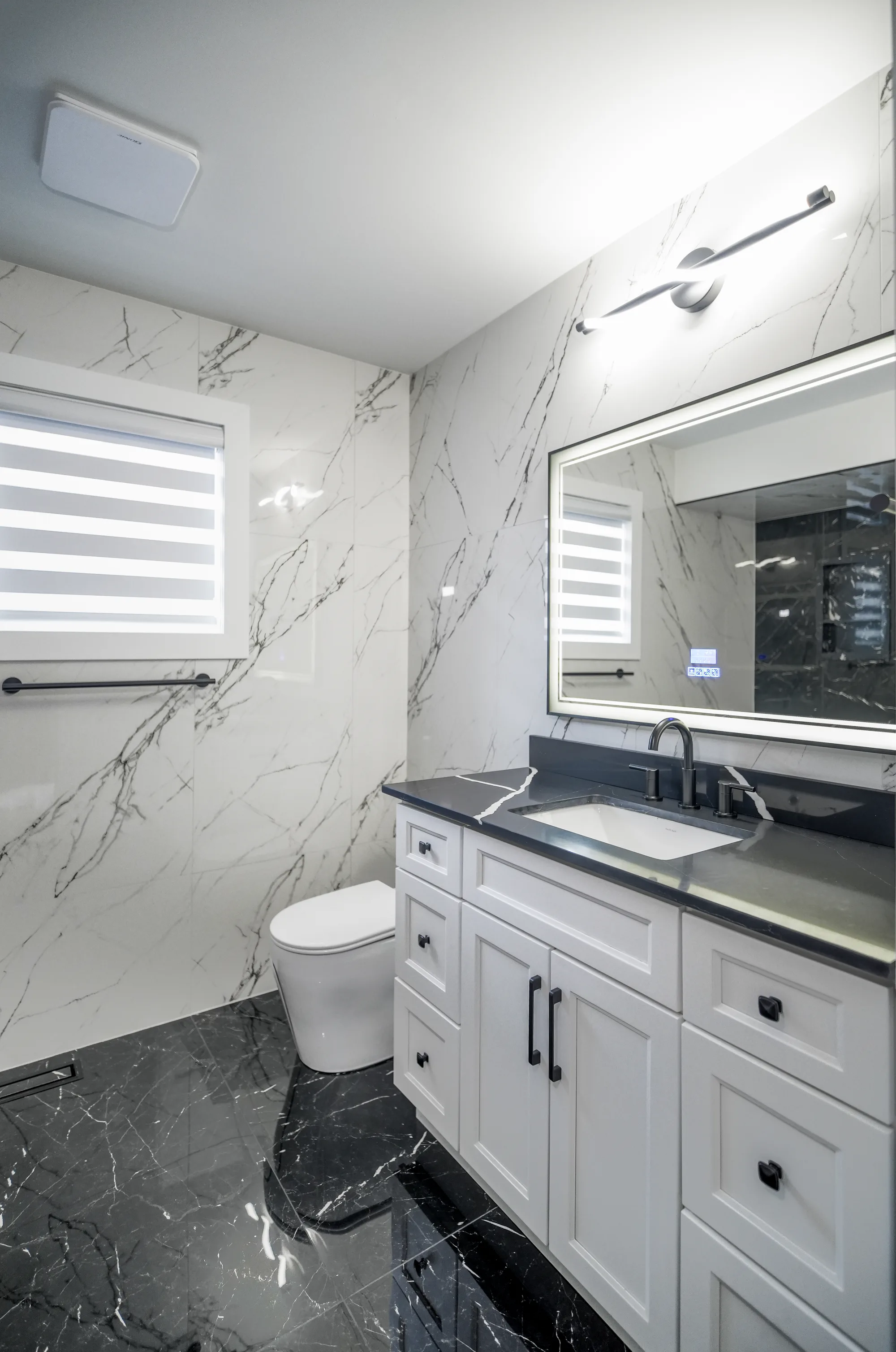 Bathroom with dramatic black and white marble tile and black hardware