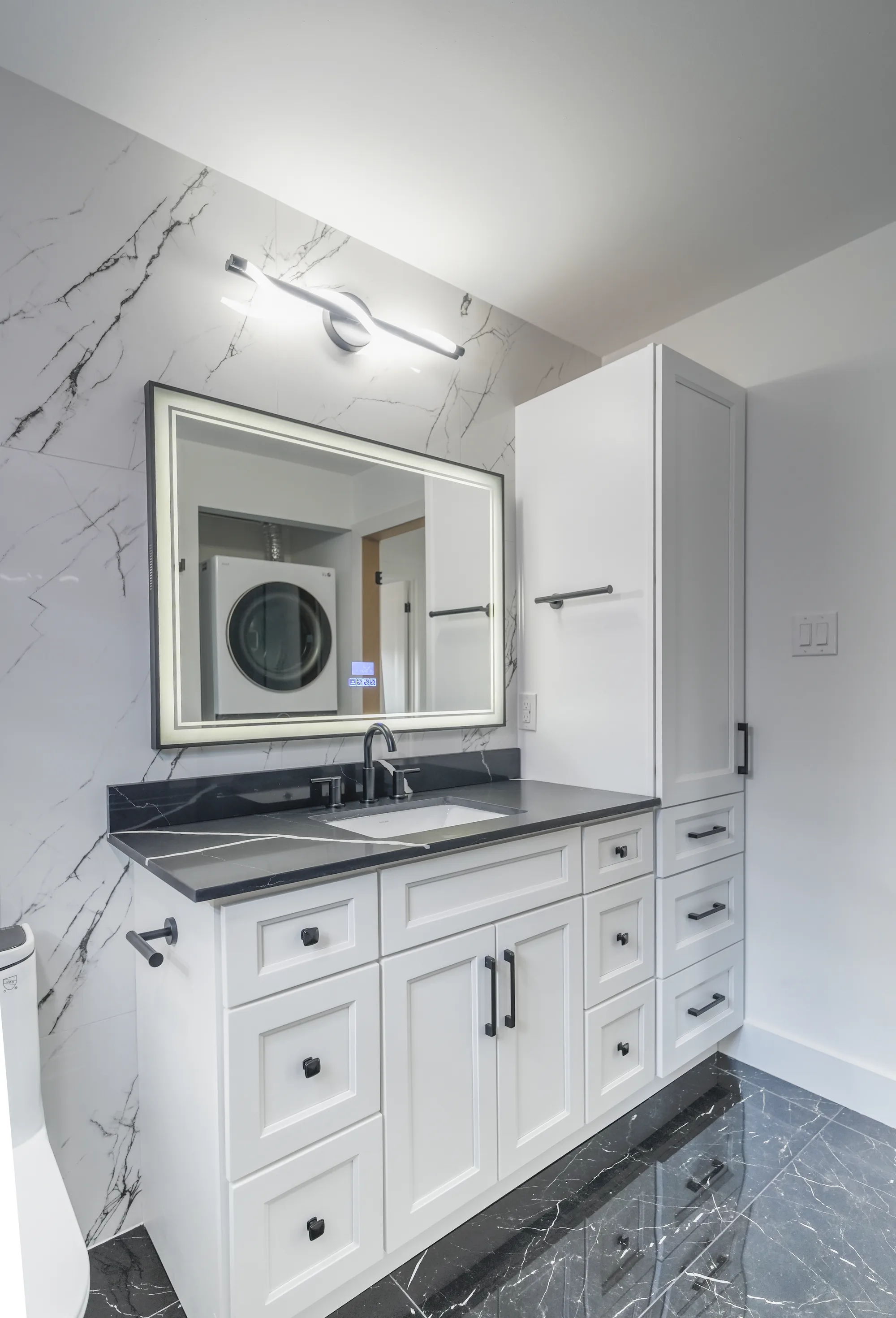 White vanity with marble walls and built-in storage