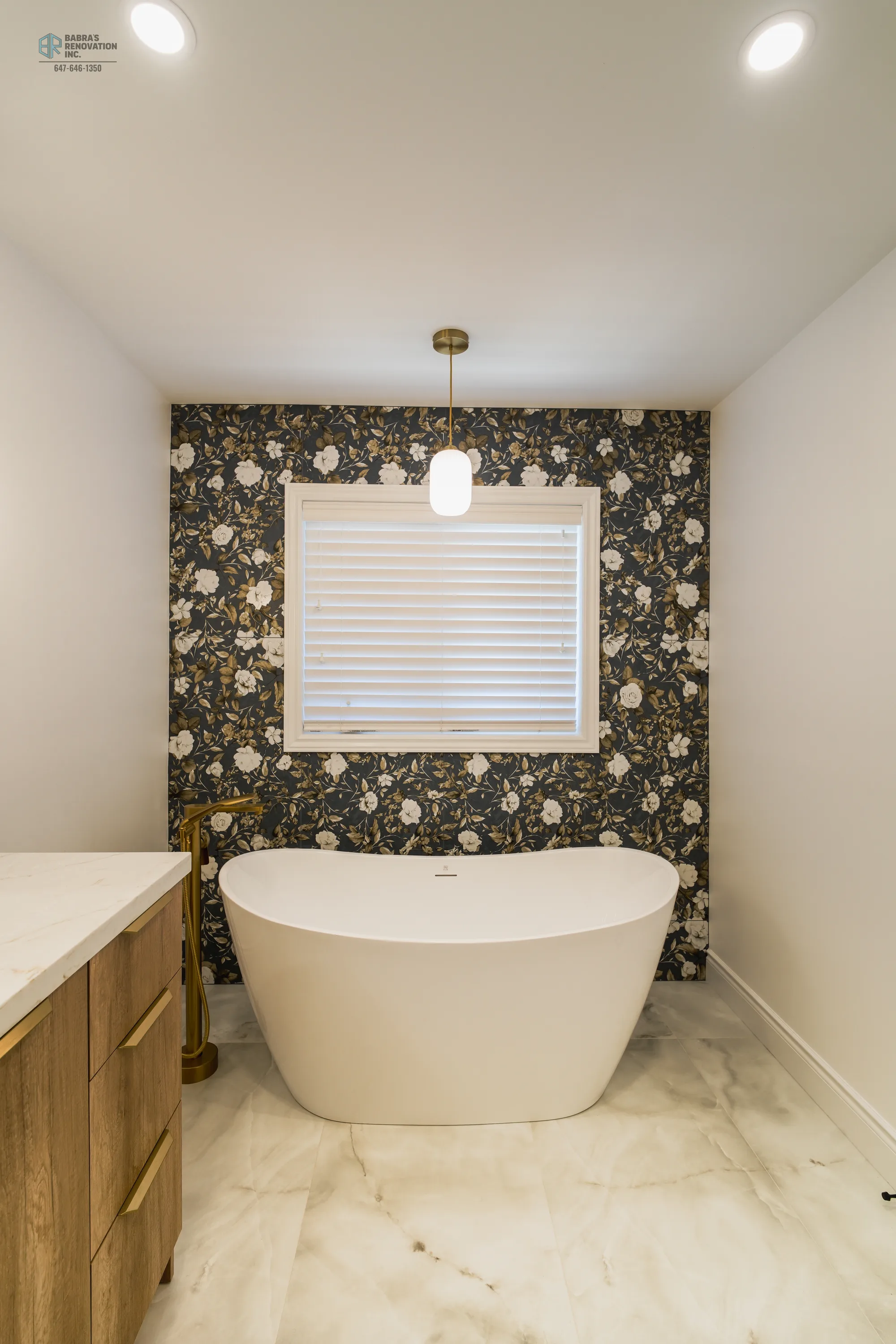 Freestanding tub with floral wallpaper accent wall