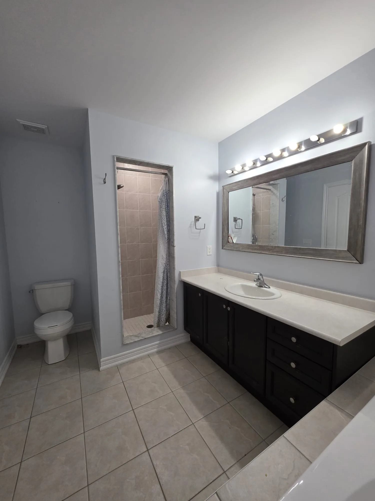 Dated bathroom with dark vanity, chrome fixtures, curtained shower stall, and pink wall tile
